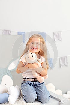 Happy smiling toothless little blonde girl. Child smiling withouth his milk teeth in children room. Sweet little redhead girl is h