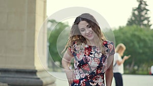 Happy smiling tourist laughing hotly on a city street. Curly attractive caucasian woman closeup summertime. The model