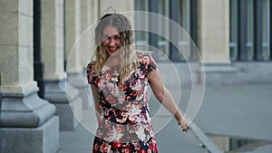 Happy smiling tourist laughing hotly on a city street. Curly attractive caucasian woman closeup summertime. The model