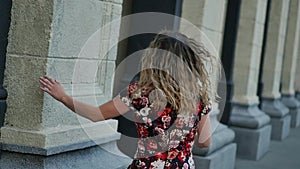 Happy smiling tourist laughing hotly on a city street. Curly attractive caucasian woman closeup summertime. The model