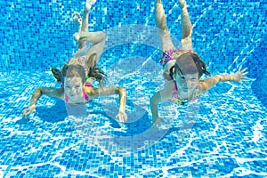 Happy smiling underwater children in swimming pool