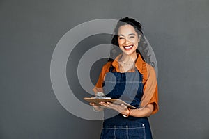 Happy smiling waitress holding clipboard to take orders