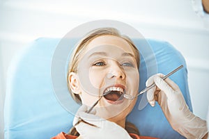 Happy smiling woman is being examined by dentist at dental clinic. Healthy teeth and medicine, stomatology concept