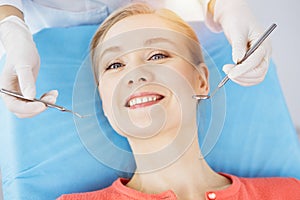 Happy smiling woman is being examined by dentist at dental clinic. Healthy teeth and medicine, stomatology concept