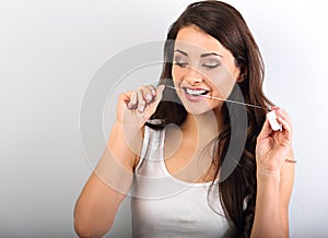 Happy smiling woman cleaning the teeth the dental floss on blue