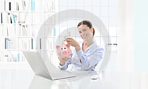 Happy smiling woman at the computer with cash and piggy bank, bu