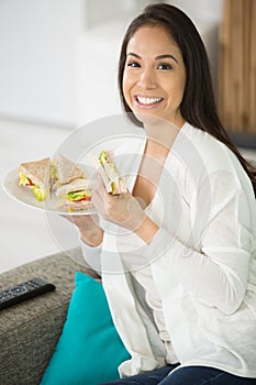 Happy smiling woman eat sandwish at home photo