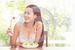 Happy smiling woman eating tomato and salad for healthy body and healthy food concept
