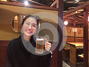 Happy smiling woman enjoy eating beer at classic restaurant in Japan