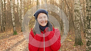 Happy Smiling Woman Enjoying Nature. Standing in autumn park. Young pretty female smiling at camera