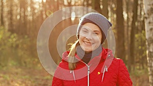 Happy Smiling Woman Enjoying Nature. Standing in autumn park. Young pretty female smiling at camera
