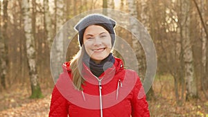 Happy Smiling Woman Enjoying Nature. Standing in autumn park. Young pretty female smiling at camera