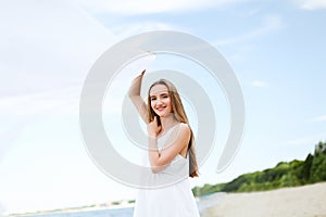 Happy smiling woman in free happiness bliss on ocean beach catching clouds. Portrait of a multicultural female model in