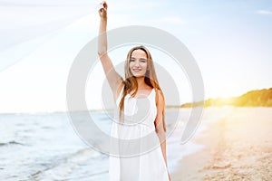 Happy smiling woman in free happiness bliss on ocean beach catching clouds. Portrait of a multicultural female model in