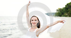 Happy smiling woman in free happiness bliss on ocean beach standing with open hands. Portrait of a multicultural female