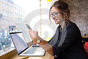 Happy smiling woman in glasses skilled business worker checking e-mail on mobile phone