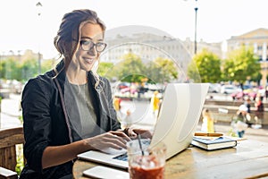 Happy smiling woman in glasses successful government worker connected to public wifi via laptop computer