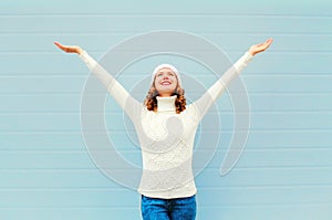 Happy smiling woman having fun rised hands up over blue photo