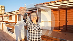Happy smiling woman holding house keys of her new house
