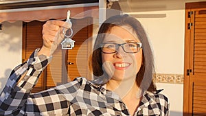 Happy smiling woman holding house keys of her new house