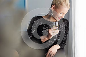 Happy smiling woman at home.drinking champagne