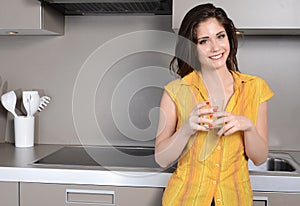 Happy smiling woman in the kithen with glass of water photo