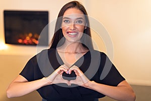 Happy smiling woman making heart shape with hands