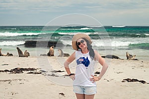 Happy smiling woman posing for a photo next to sea lions on Kangaroo Island