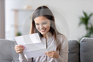 Happy smiling woman reading paper letter, receive good news at home