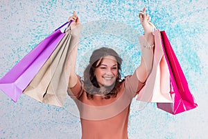 Happy smiling woman at shopping holds colourful paper bags, pack
