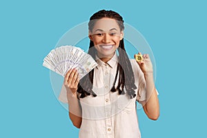 Happy smiling woman showing bitcoin and big fan of money, e-commerce, crypto currency.