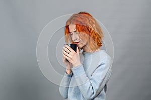 Happy smiling woman with towel on her head enjoying freshness and well-being, gray background. Apply the cream on the face,