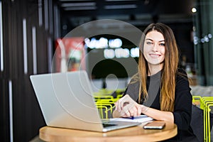 Happy smiling woman working with laptop in modern smart space hub photo