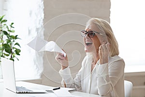 Happy smiling 60 years old businesswoman using laptop. photo