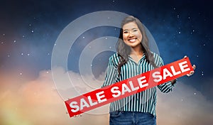 Happy smiling young asian woman with sale banner