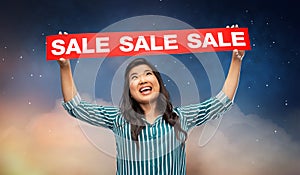 Happy smiling young asian woman with sale banner