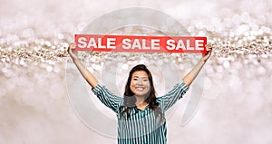 Happy smiling young asian woman with sale banner