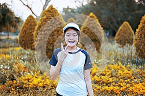 Happy and smiling young asian woman standing and rais up hands while taking a break after running at public park,Positive thinking