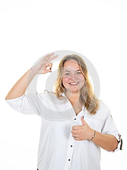 Happy smiling young beautiful business woman with okay gesture showing thumb up sign on white background
