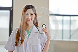 Happy smiling young beautiful female doctor showing blank area f