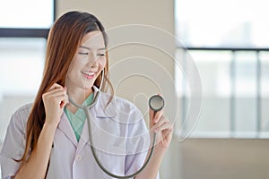 Happy smiling young beautiful female doctor showing blank area f