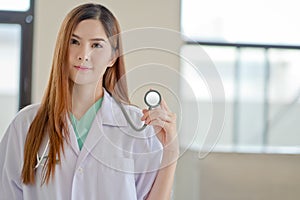 Happy smiling young beautiful female doctor showing blank area f