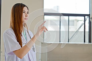 Happy smiling young beautiful female doctor showing blank area f