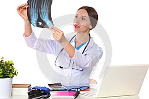 Happy smiling young beautiful female doctor showing blank area for sign or copyspace, over white background