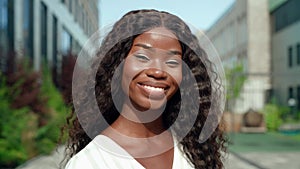 Happy smiling young black African woman posing outdoors for portrait.