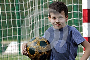 Happy smiling young boy with football ball