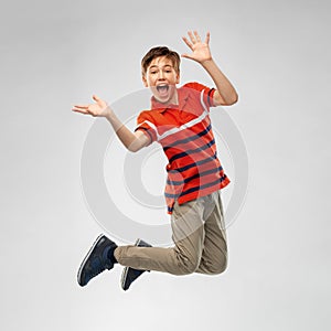 Happy smiling young boy jumping in air