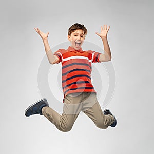 Happy smiling young boy jumping in air