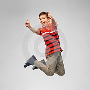 Happy smiling young boy jumping in air