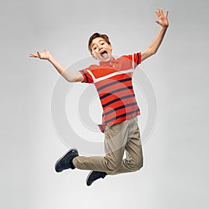 Happy smiling young boy jumping in air